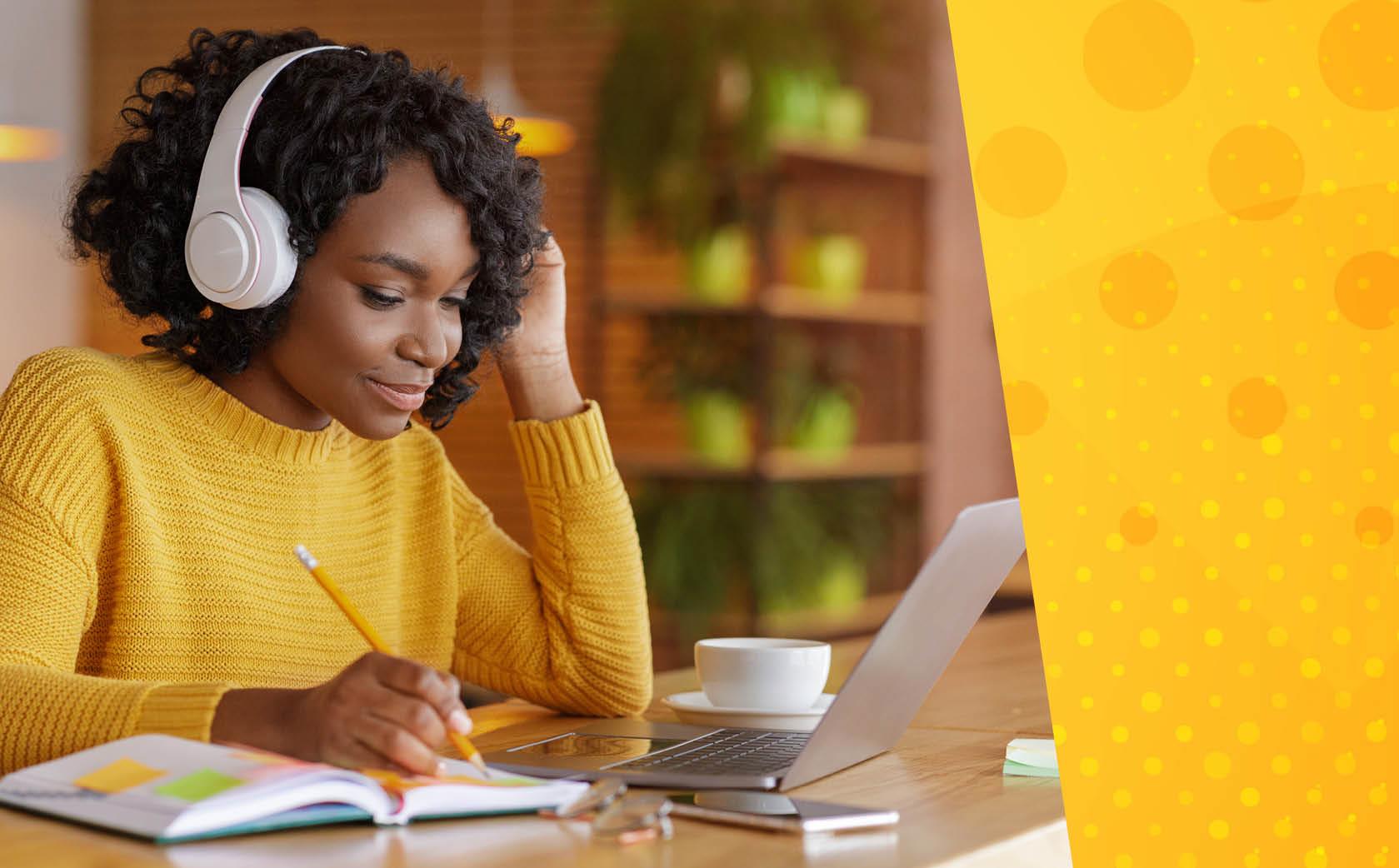 Black woman in yellow sweater with headphones taking notes